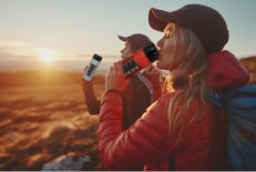 Eine junge Frau und ein junger Mann, die die WEPA 2in1 Trinkflasche während eines Outdoor-Trips nutzen.