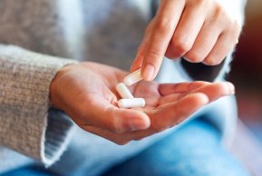 Eine Hand in Nahaufnahme, darin Kapseln.