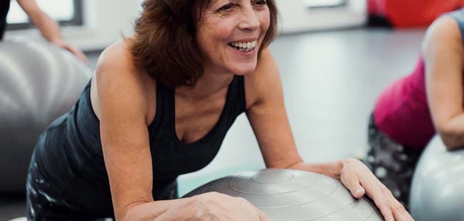 Eine Frau macht Sport mit einem Gymnastikball