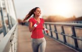 Pferdesalbe anwenden  Eine Frau joggt über eine Brücke